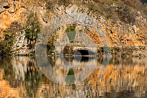 Reflexión de la roca a pequeno puente en Agua 