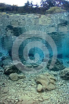 Reflection of rocks underwater in lake.