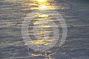 Reflection of the setting sun on the surface of the ice rink. Texture and backgrounds
