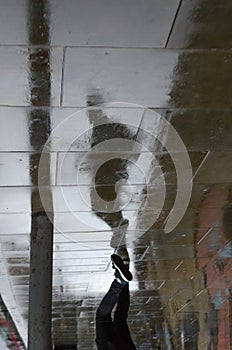 Reflection and silhouette of a man walking on the sidewalk