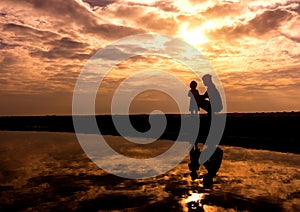 Reflection Silhouette of mother with her toddler against the sun