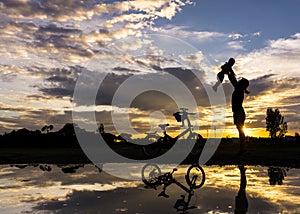 Reflection Silhouette of mother with her toddler against the sun