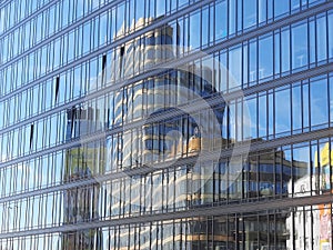 Reflection of a skyscraper in the glass facade of the building