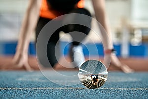 Reflection of sportive woman in glass ball during her running training