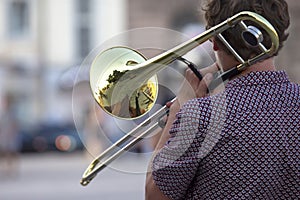 Reflection of the street in the instrument solo trumpet. male musician plays the trombone. music and creativity. jazz and Blues