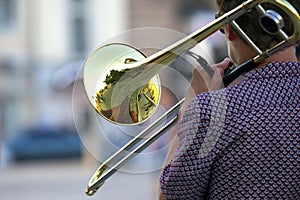 Reflection of the street in the instrument solo trumpet. male musician plays the trombone. music and creativity. jazz and Blues