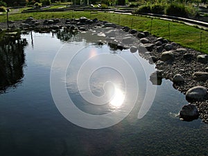 Reflection of the sun in the pond,  stones, Helsinki, Finland