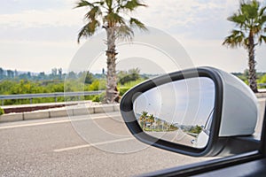 Reflection of the sun in the side mirror of a car. Autotravel concept. photo