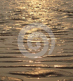 Reflection of a sunset on sandy water's edge