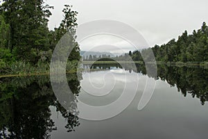 Reflection of trees in the water at Lake Matheson on an overcast