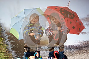 Reflection of two little boys with umbrellas