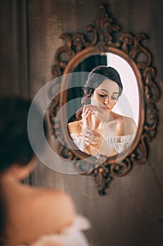 Reflection in vintage mirror young beautiful medieval lady. brunette woman