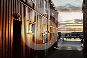 Reflection of warm sunrise in facade of fishermen\'s hut at Hamnøy in Lofoten, Norway