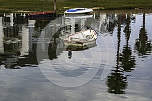 Reflection in the water of fishing boats standing on the pier in the sea bay