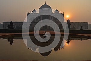 A reflection in water and mesmerizing view of humayun tomb memorial from the main gate,entrance at winter foggy morning