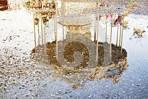 Reflection in the water of an old abandoned children`s carousel.