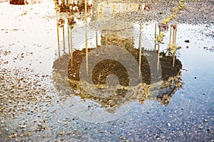 Reflection in the water of an old abandoned children`s carousel.