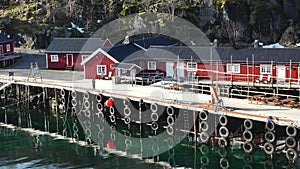 Reflection in the water. Snowy mountains, fishing village. Bright red houses on the ocean. Lofoten islands in Norway