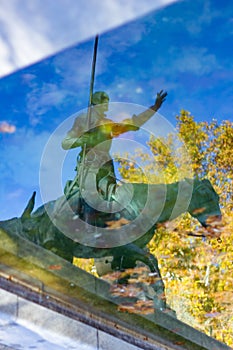 Reflection in the water of a statue of Don Quixote