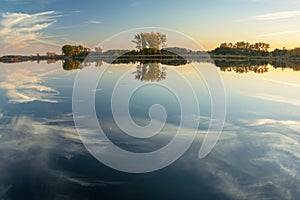 Reflection of white clouds in the water of a calm lake