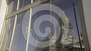 Reflection in window of ancient cathedral. Action. Ancient cathedral with dome is reflected in window of modern building