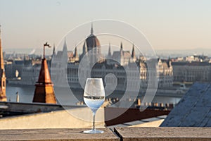 Reflection in wine glass of Hungary Paliament hazy figure in the background