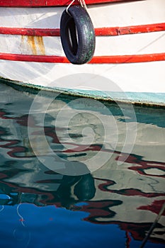 Reflection of a wooden fishing boat in water