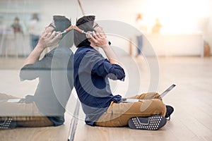 Young Asian business man listening to music while using laptop