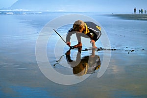 Reflection of Young Boy Writing in Beach Sand