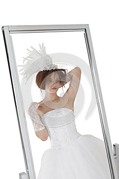 Reflection of young bride in mirror over white background