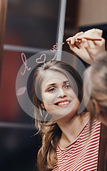 Reflection of young woman face in mirror with inscription