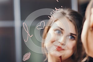 Reflection of young woman face in mirror with inscription