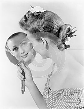 Reflection of a young woman, looking in a mirror