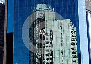 Reflections in the blue windows of a tall office building