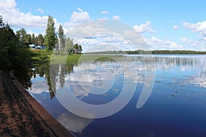 Reflections of clouds and trees on Lake Ranuanjarvi in Finland