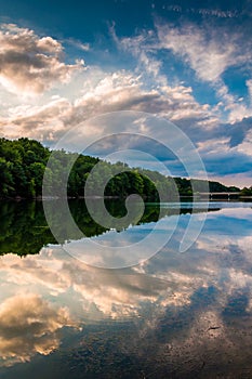 Reflections of clouds and trees at sunset in Lake Marburg, Codorus State Park, Pennsylvania.
