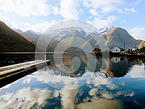 Reflections of the fjords and clouds on the water in Urke, Norway