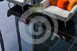 reflections of furniture on highgloss black floor tiles