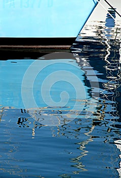 Reflections of the masts of a sailboat