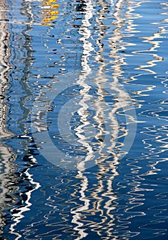 Reflections of the masts of some sailboats