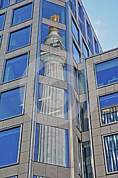 Reflections of the Monument to the great fire in London in the financial district of the City of London