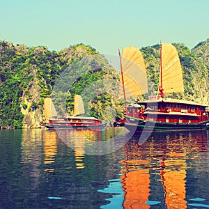 Reflections of sailing junks on Ha Long Bay Vietnam photo