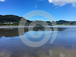 Reflections on surface of 90 Mile Beach, Ahipara, New Zealand