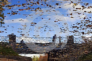 Reflections of two people in the water.