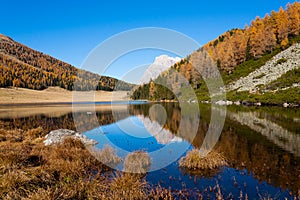 Reflections on water, autumn panorama from mountain lake