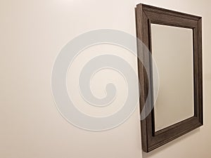 Mirror in wood frame on white wall