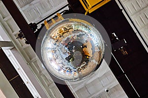Reflective large disco ball on ceiling of old building