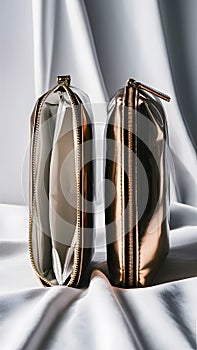 Reflective metallic pouches, one open, one sealed, shine in symmetrical beauty on white backdrop