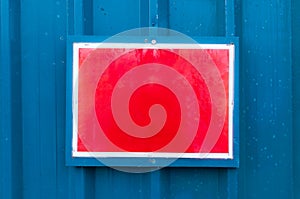 Reflective red notice board mounted on metal background