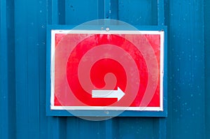 Reflective red notice board showing direction mounted on metal b